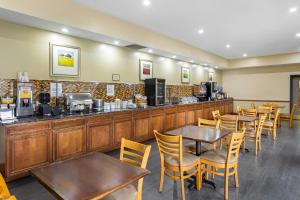 a restaurant with tables and chairs and a counter at Country Inn & Suites by Radisson, Jacksonville West, FL in Jacksonville