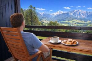 a man sitting at a table with a cup of coffee at SKYWAY LOFT - Residence Veronza con piscina, Dolomiti Affitti in Cavalese +68 photos
