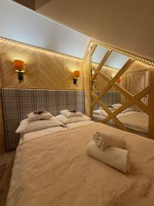 a bedroom with two beds with a cat laying on them at Domek Zyngierka Tatra View - balia I sauna na wyłączność in Bańska Wyżna