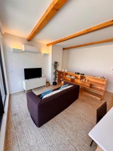 a living room with a couch and a flat screen tv at Rooftop Teatro Aveiro in Aveiro