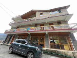 a car parked in front of a building at Hotel sno cottage in Vashisht