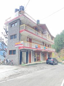 a building with a car parked in front of it at Hotel sno cottage in Vashisht +5 photos