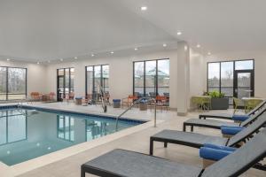 a swimming pool with benches and chairs in a building at Hampton Inn By Hilton Richmond Chester, VA in Chester