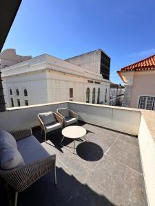a patio with a table and chairs on a balcony at Rooftop Teatro Aveiro in Aveiro