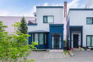 a white building with a blue front door at THE CITYSCAPE in Kita-sanjō