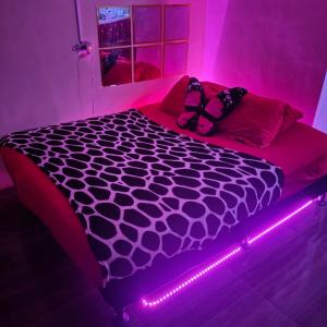 a bed in a room with a pink light at Ciel's Deluxe Haven in Binangonan