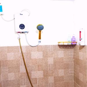 a shower with a hose attached to a wall at Ciel's Deluxe Haven in Binangonan