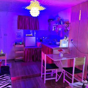 a purple room with a table and chairs in it at Ciel's Deluxe Haven in Binangonan