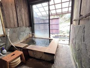 ein Badezimmer mit Badewanne und Fenster in der Unterkunft 阿蘇扇温泉 おおぎ荘 in Minamioguni + 39 Fotos