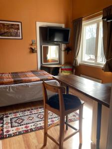 a room with a desk and a bed and a chair at Hen Stasjon Banevokterboligen in Hen