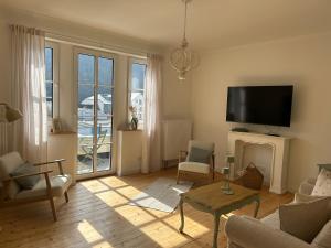 a living room with a fireplace and a tv at Residenz Moselliebe Traben in Traben-Trarbach