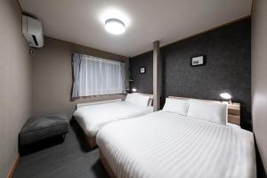 a hotel room with two beds and a television at THE CITYSCAPE in Kita-sanjō