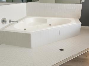 a white bath tub in a white tiled bathroom at Rancho San Diego Inn & Suites in El Cajon +11 photos