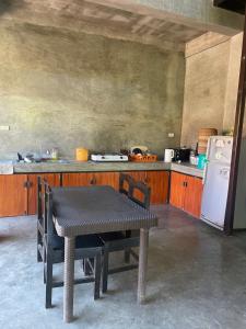 a kitchen with a table and a white refrigerator at jbsurf House in Catagnan