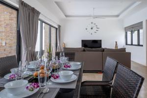 a dining room with a table and chairs and a couch at villa carissa 9 in Nathon Bay