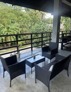 a patio with chairs and a table on a balcony at jbsurf House in Catagnan