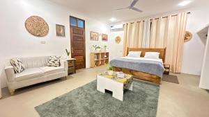 a bedroom with a bed and a couch and a table at MG Villa, Zanzibar in Mfumbwi +26 photos