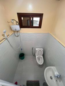 a small bathroom with a toilet and a sink at Banaue Greenfields Inn and Restaurant in Banaue