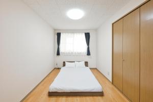 a small bedroom with a bed and a window at STAY IN PASSION in Asahikawa