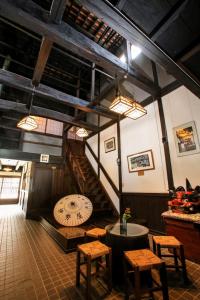 a room with a staircase and a table and chairs at Oyado Iseya in Shiojiri