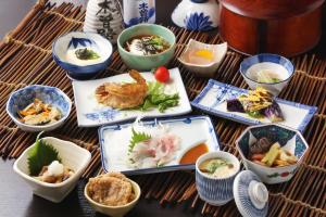 a table with plates of food and bowls of food at Oyado Iseya in Shiojiri