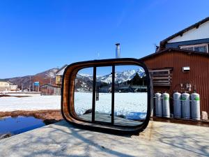 a mirror sitting on the side of a building with snow at HAYU Hearth Yuzawa in Yuzawa