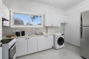 a white kitchen with a sink and a washing machine at Urban Condo Promitheos in Nicosia