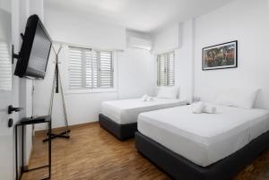 a bedroom with two beds and a flat screen tv at Urban Condo Promitheos in Nicosia