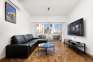 a living room with a black couch and a table at Urban Condo Promitheos in Nicosia