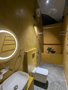 a bathroom with a sink and a toilet and a mirror at Earth's Embrace in Kalpetta
