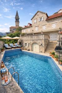 a large swimming pool in front of a building at Conte Hotel & Restaurant in Perast