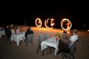 a group of people sitting at tables on the beach at Koh Apikjun Resort by EHM in Kaoh Sdach +154 photos