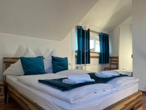 a bedroom with a large bed with blue pillows at Pensiunea Andra in Jurilovca