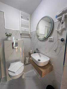 a white bathroom with a sink and a mirror at Pensiunea Andra in Jurilovca +104 photos