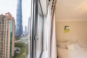 a bedroom with a bed and a large window at Today-Lujiazui Riverside,Bund Riverview in Shanghai