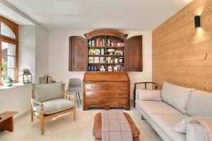 a living room with a couch and a wooden cabinet at Garden Heart of the village Swedish Stove in Champéry