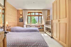 a bedroom with two beds and a window at Garden Heart of the village Swedish Stove in Champéry