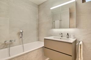 a bathroom with a sink and a tub and a mirror at Garden Heart of the village Swedish Stove in Champéry +17 photos