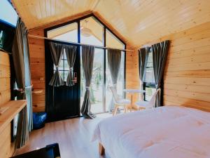a bedroom with a bed and a large window at Roben Village in Suseni