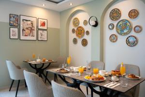 a dining room with two tables and plates on the wall at Pietro Boutique Hotel and Villas in Għarb