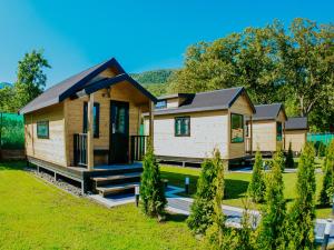 a log home with a porch and a yard at Roben Village in Suseni