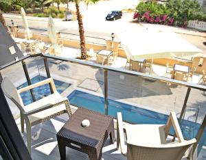 a balcony with chairs and a table and a swimming pool at Taşucu Kaptan Suit Otel in Silifke