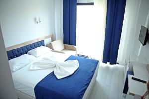 a bedroom with a blue bed with a bow on it at Taşucu Kaptan Suit Otel in Silifke +1 photo