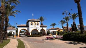 a building with palm trees in front of it at Villa with private pool and BBQ on Mar Menor Golf Resort in Torre-Pacheco