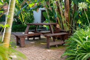 a picnic table and bench in a garden at Hôtel La Kapila Ivato in Ivato