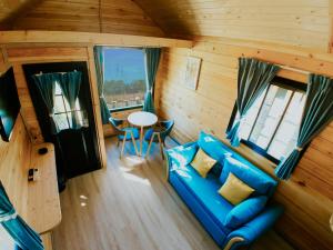 a living room with a blue couch and a table at Roben Village in Suseni