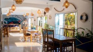 a dining room with tables and chairs in a room at Hôtel La Kapila Ivato in Ivato