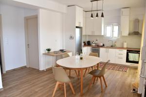 a kitchen and dining room with a table and chairs at Maria's Dreamhouse in Egina