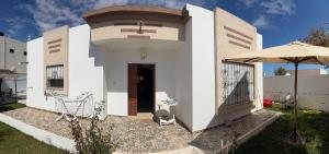 a small white building with a door and an umbrella at Villa Al-Qamar in Midoun