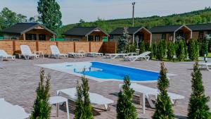 a resort with a pool and chairs and buildings at Roben Village in Suseni
